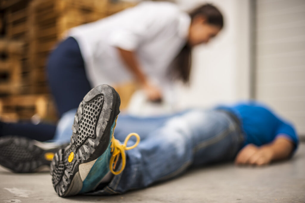 homme adulte allongé au sol ayant un problème cardiaque