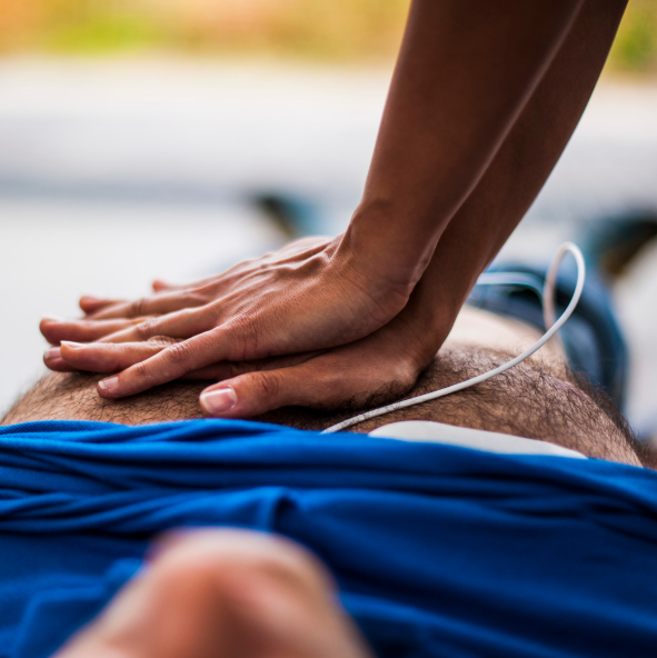 16 octobre : gestes qui sauvent et défibrillateur Mains effectuant des compressions thoraciques, avec une électrode de défibrillateur visible